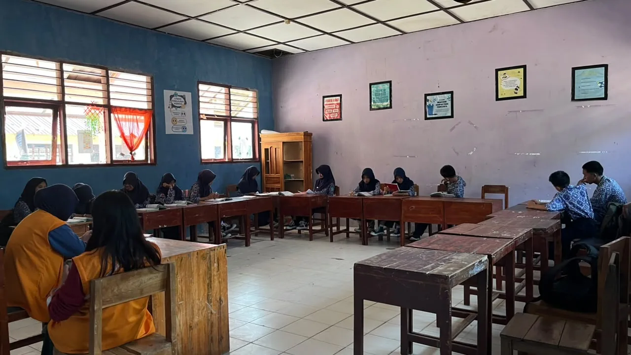 Siswa belajar dan membaca di ruang kelas.